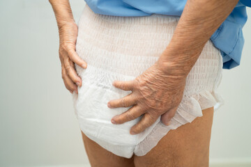 Asian elderly woman wearing diaper for loss of bladder urinary incontinence control.