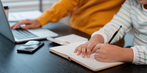 Mother and Daughter Working Together at Home, Using Laptop and Writing in Notebook, Family Bonding and Education Concept