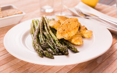 Dietary meal rich in protein. Stir fried chicken breast and green asparagus