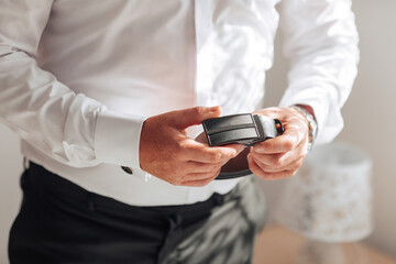 A man is wearing a white shirt and black pants