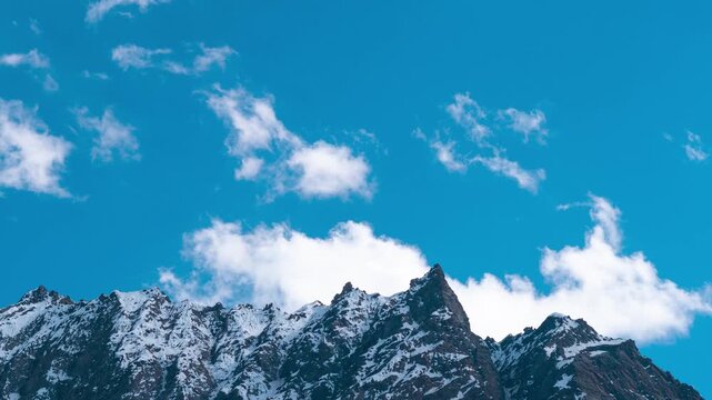 4K Timelapse of clouds moving in blue sky over snow covered Himalaya mountains in Jispa at lahaul, Himachal Pradesh, India. Nature landscape. Summer season clouds and mountains time lapse. 