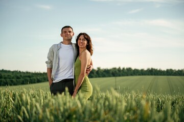 Standing and posing. Lovely couple are on the agricultural field together