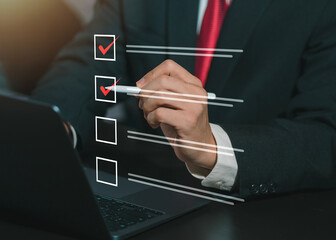 Businessman using laptop to give accurate scores, complete online surveys, digital form checklists,...