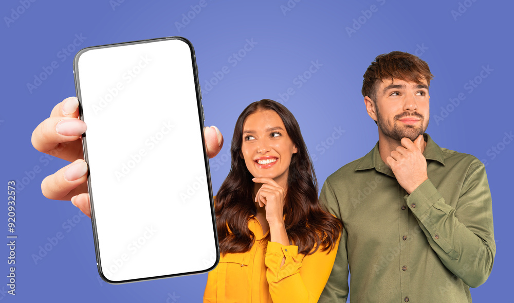 Poster a woman holds a smartphone with a blank screen in front of a blue backdrop. she is smiling and looki