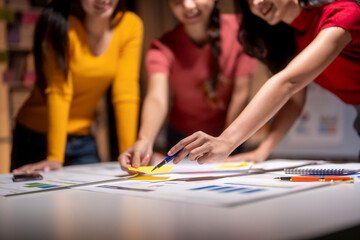 Fototapeta premium Marketing team working on project using sticky notes and brainstorming in office at night