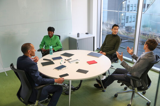Businesspeople having meeting in office; Group of businesspeople�having meeting at round table in modern office
