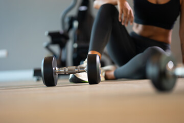 dumbbells at gym background banner. beautiful young hispanic woman wearing sporty fitness clothes doing exercise indoors at gym fitness sport club, body and health care