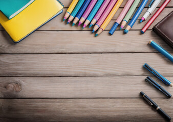 Colored pencils on a wooden table. Back to school concept. Stationery composition.