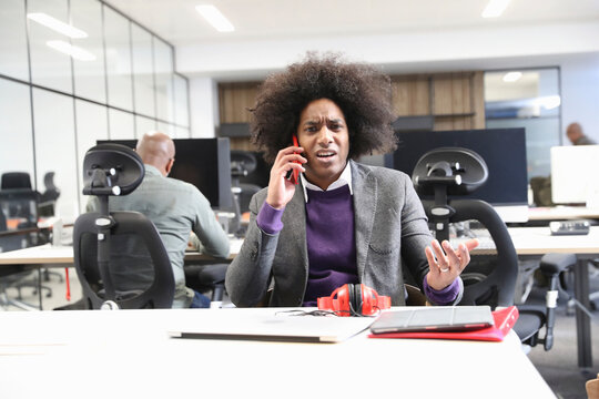Businessman talking on smart phone in office