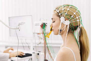 The patient is preparing for a brain activity scan. Ideal for illustrating modern medical diagnostics and healthcare technology.