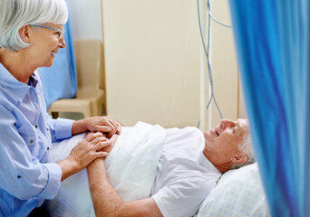 Hospital, bed and old man with wife, sick and senior care with health insurance, holding hands and smile. Couple, talking and healthcare for elderly person, medical and love in clinic and illness