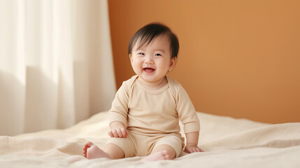 Fototapeta premium Smiling baby sitting on soft bedding in a cozy, warmly lit room.