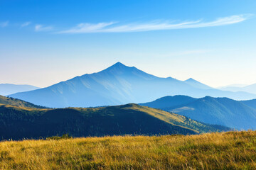 A breathtaking view of mountain peaks under a clear blue sky, with rolling hills and meadows in the foreground, showcasing natural beauty and serenity.