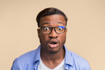 Fototapeta premium Astonishment. Surprised African American Guy Looking At Camera With Opened Mouth Posing Over Yellow Studio Background.