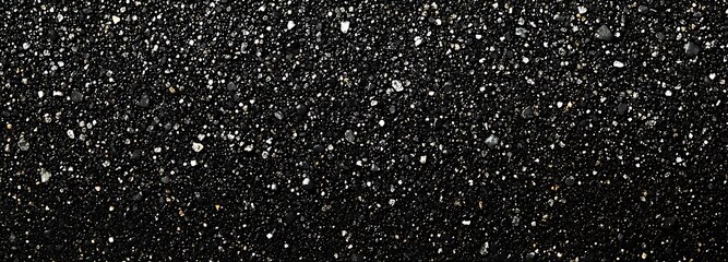 Obraz premium Close-up of black sand with small white and gold pebbles.