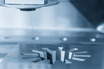 Closeup scene the wire EDM machine cutting the mold parts in the light blue scene.