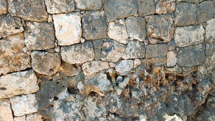 A wall made of stone with a few holes in it