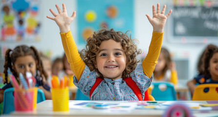 A happy girl with her arms raised in the classroom. Concept of the start of the school year and early childhood education.