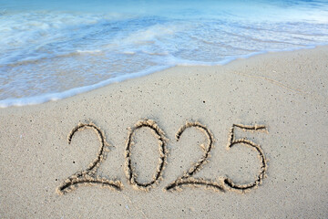 2025 hand written in sand on a beautiful beach