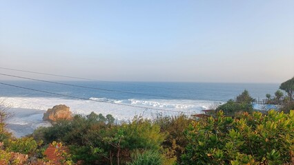 A beautiful beach with a rocky shoreline and a clear blue sky © Tina