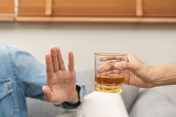 Alcoholism, depressed asian young man refuse, push out alcoholic beverage glass, drink whiskey,...
