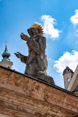 Obraz premium Freising, Bavaria, Germany - August 3, 2024: Town Hall, a historic building (1904) in the middle of the old town. In the foreground Saint Sigismund who kneels on the marble base of the Marian column