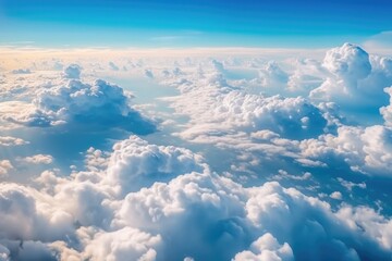 Fototapeta premium Blue sea of clouds. The aerial view from the airplane window during a trip.