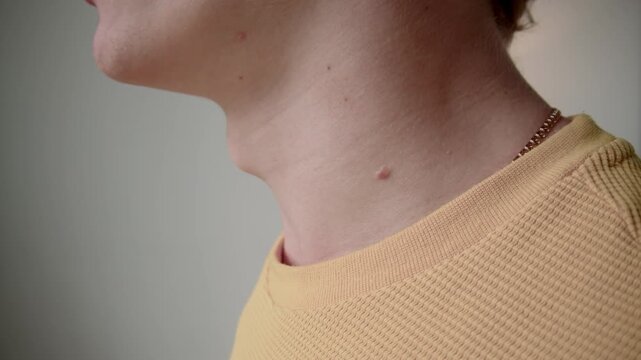 Side cropped closeup of anonymous man moving Adams apple and massaging neck after sedentary job indoors