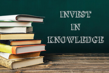 A stack of books with the words invest in knowledge written on top