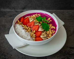 Healthy breakfast bowl featuring a mix of fruits, granola, and coconut flakes.