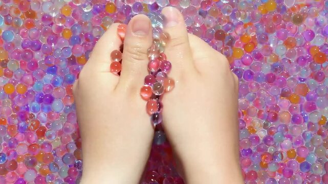 The girl's hands slowly pick up colored orbis in her palms and gently squeeze them and calmly scatter them. View from above. Part 4. Asmr. Visual and sound effects for relaxation and peace.