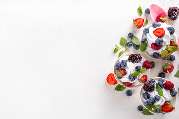 Frozen yogurt dessert with various berry toppings. Whipped creamy yoghurt ice cream with raspberry, strawberry, blueberry and mint
