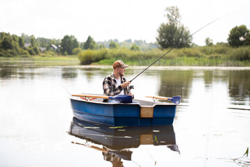 fisherman fishing on a rowing boat, fisherman casting a spinning rod, fishing on the river, men's...