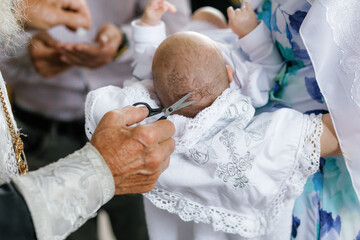 The priest cuts off the hair on the baby's head, church rites and traditions.
