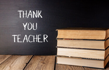 A stack of books with a chalkboard underneath that says Thank You Teacher