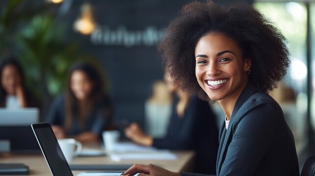 Confident Leader, Bright Future: A young Black businesswoman radiates success, smiling confidently from her laptop in a bustling office environment. 