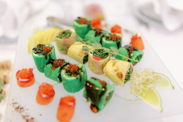 Multi-coloured sushi on a large plate. 