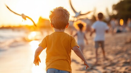 A young boy in an orange shirt runs across the beach while seagulls fly around him at sunset, with other children enjoying the beach in the background, creating a lively scene.