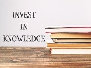 A stack of books with the words invest in knowledge written on top