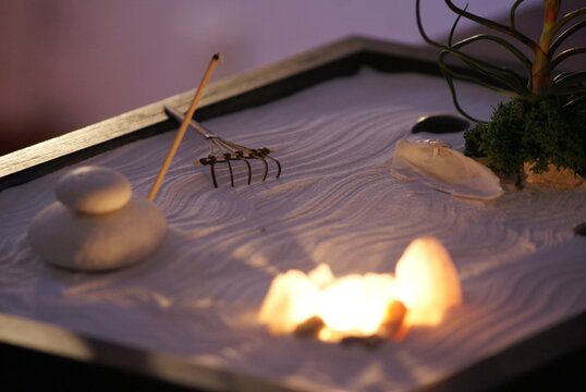 A mini zen garden is a small space containing elements and arrangements that promote peace and tranquility often used for meditation or relaxation.