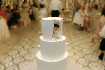 Cut a slice off a beautiful white wedding cake.