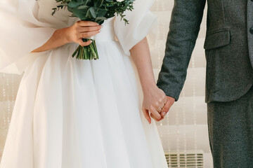 The newlyweds are holding hands, you can't see their faces.