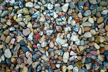 Pebbles close-up. Remains of white paint on them. Gravel background