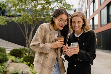 young pretty women walking talking in street doing business