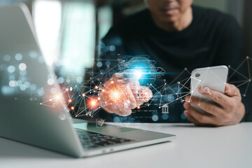 International trade, digital marketing, and e-commerce concept. A businessman using social media marketing, IoT, and worldwide internet access technology on a laptop and a mobile phone