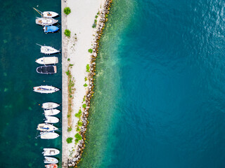 Fototapeta premium Aerial drone view of Lago di Garda (lake Garda) coastline, Italy. The beach and fresh blue water.
