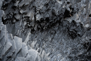 close up black volcanic rock formation in Iceland. Steep cliff rock formation. 