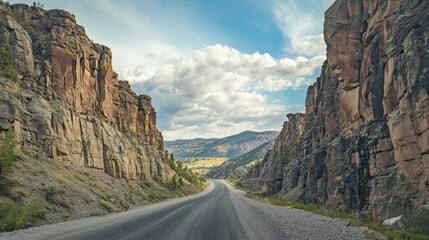 A breathtaking view of a mountain road with dramatic rock formations on either side, capturing the rugged beauty and challenging terrain of the route.