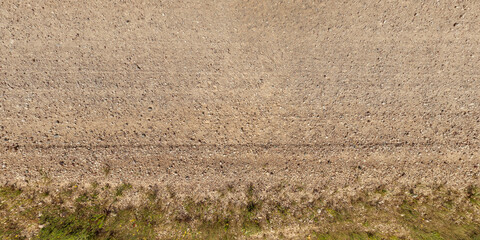 view from above on texture gravel road with median with lawn