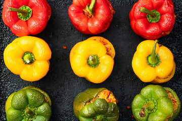 Baked stuffed pepper ( paprika ) with rice , carrot and meat . Top view on rustic background